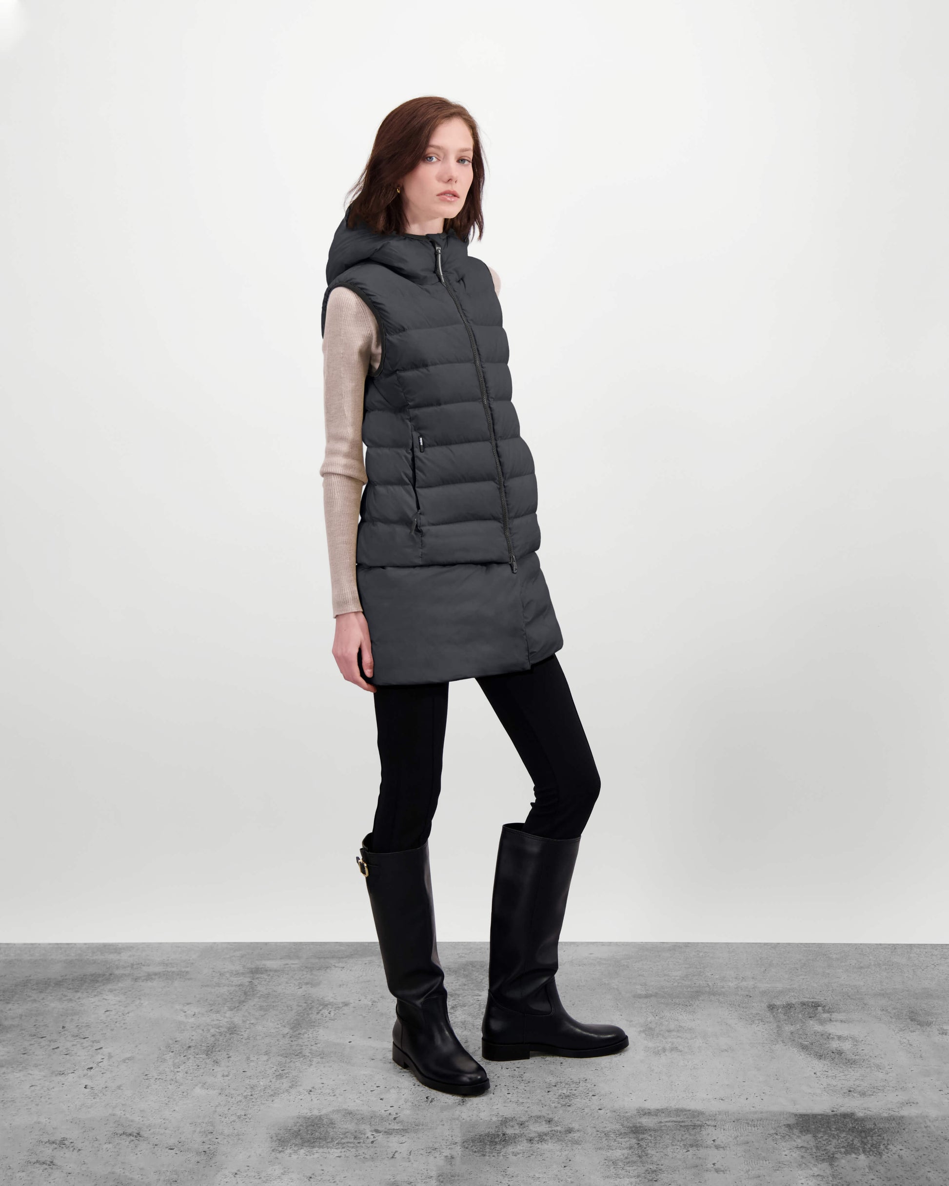 Saratoga puffer vest in Black insulated with Canadian white duck down, featuring stretch nylon ribbing for mobility, hidden waist drawcord, and a tailored fit for warmth and style. Lightweight and ideal for layering.