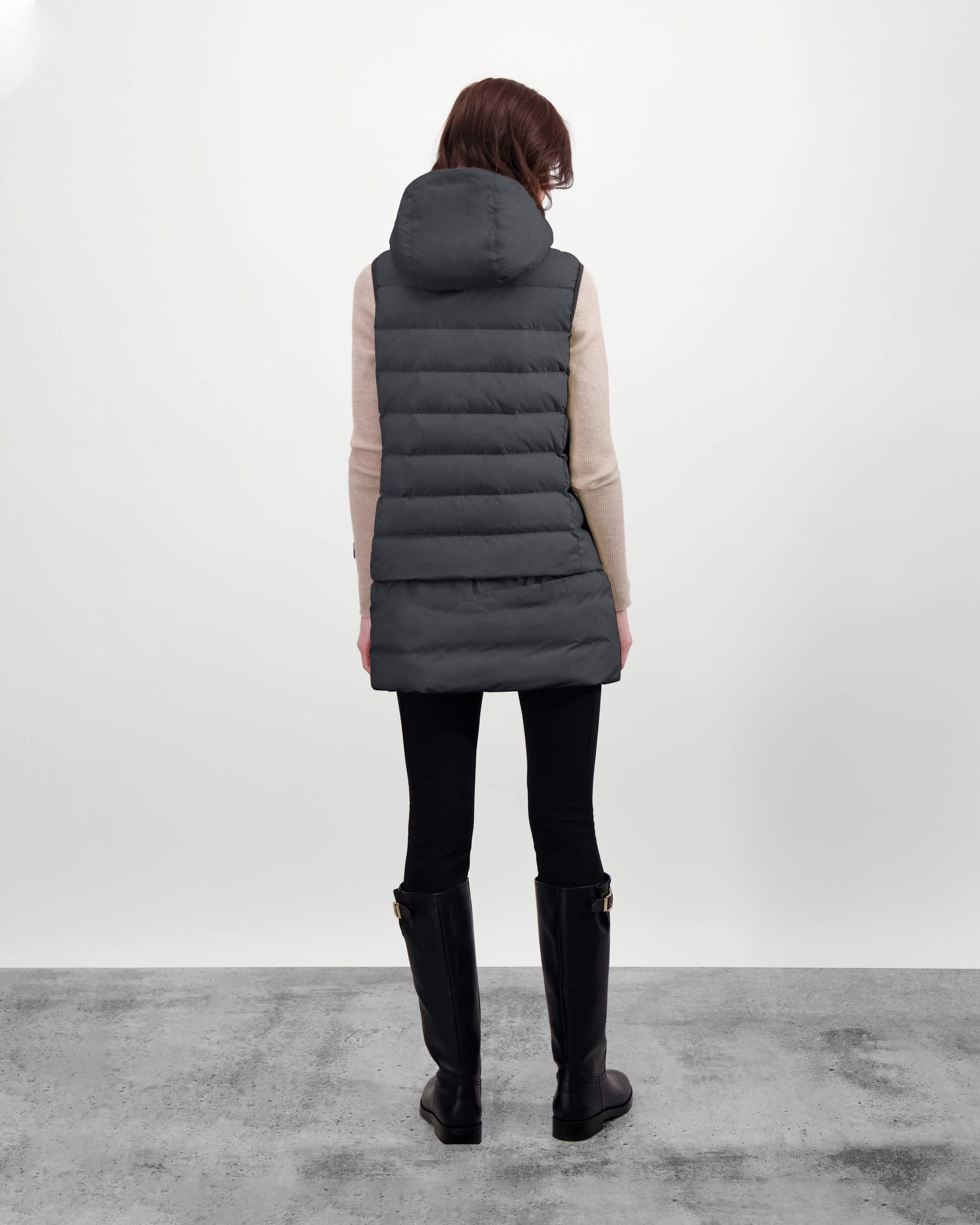 Saratoga puffer vest in Black insulated with Canadian white duck down, featuring stretch nylon ribbing for mobility, hidden waist drawcord, and a tailored fit for warmth and style. Lightweight and ideal for layering.