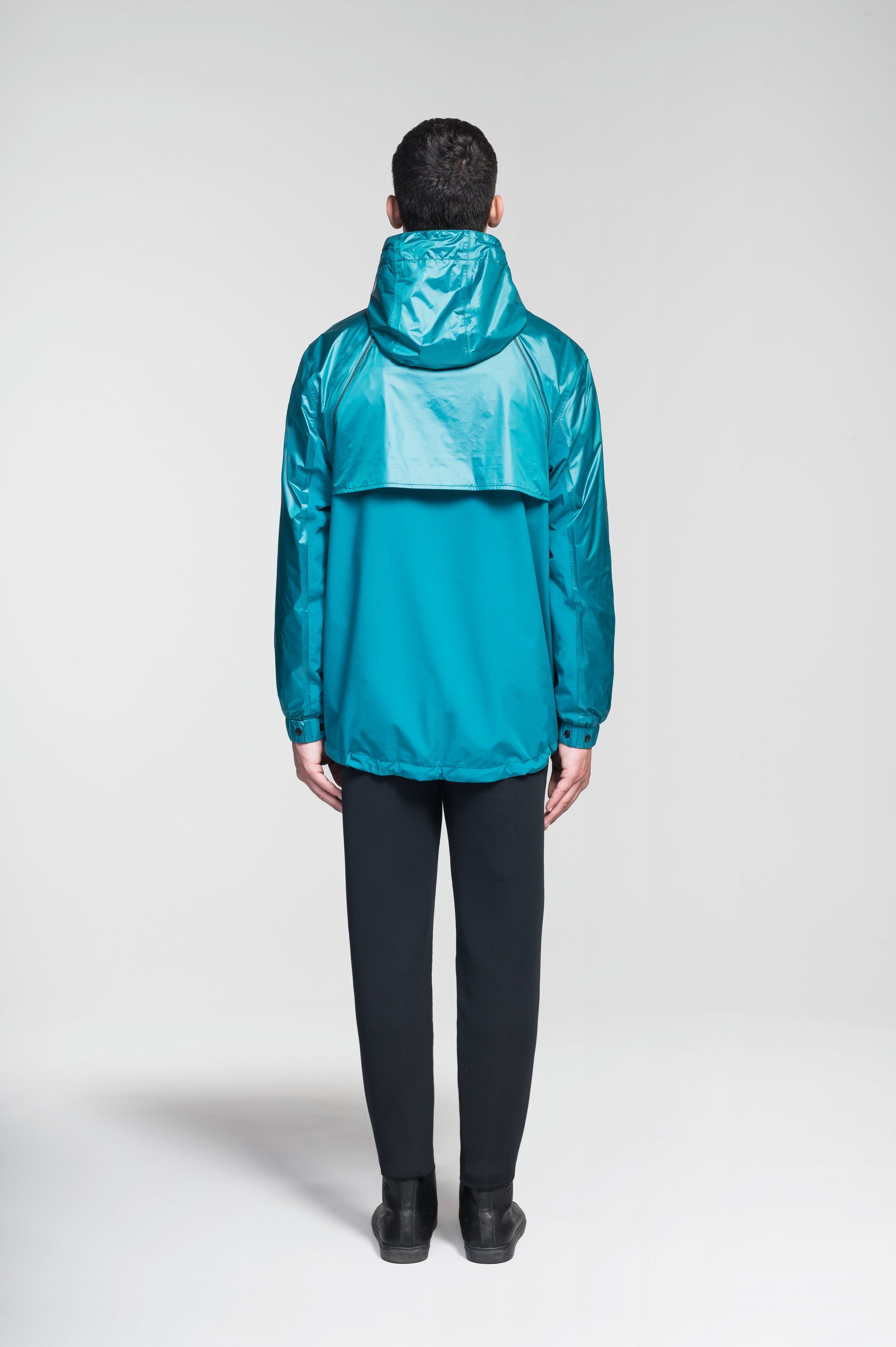 Stratus Men's Tailored Packable Rain Jacket in hip length, premium cire technical nylon taffeta and stretch ripstop fabrication, highly breathable mesh lining, hidden packable pocket, non-removable hood with adjustable draw cord, reflective piping along front and back, underarm grommets for extra breathability, back yoke with mesh ventilation, two waist zipper pockets, two interior zipper pockets, elastic cuffs with adjustable snap button, and adjustable interior draw cord at waist hem, in Deep Lake