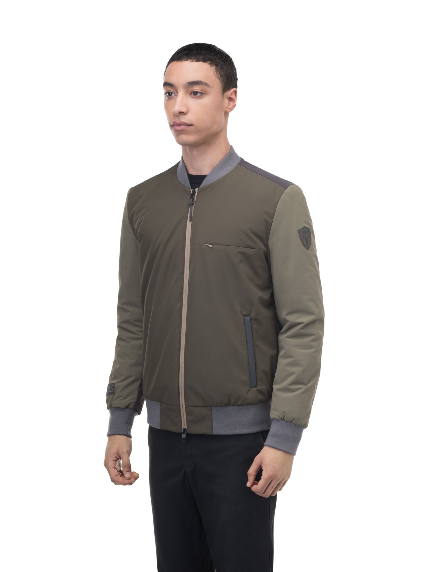 Unisex hip length bomber jacket with a contrast colour back panel, and zipper pockets at waist and an invisible zipper pocket at chest, in Dusty Olive/Licorice