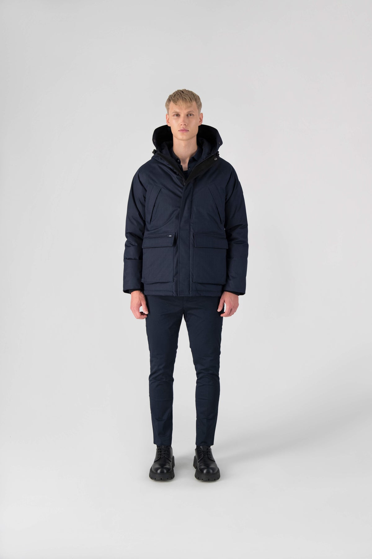 Men's waist length down filled jacket with two front pockets with magnetic closure and a removable fur trim on the hood in Navy
