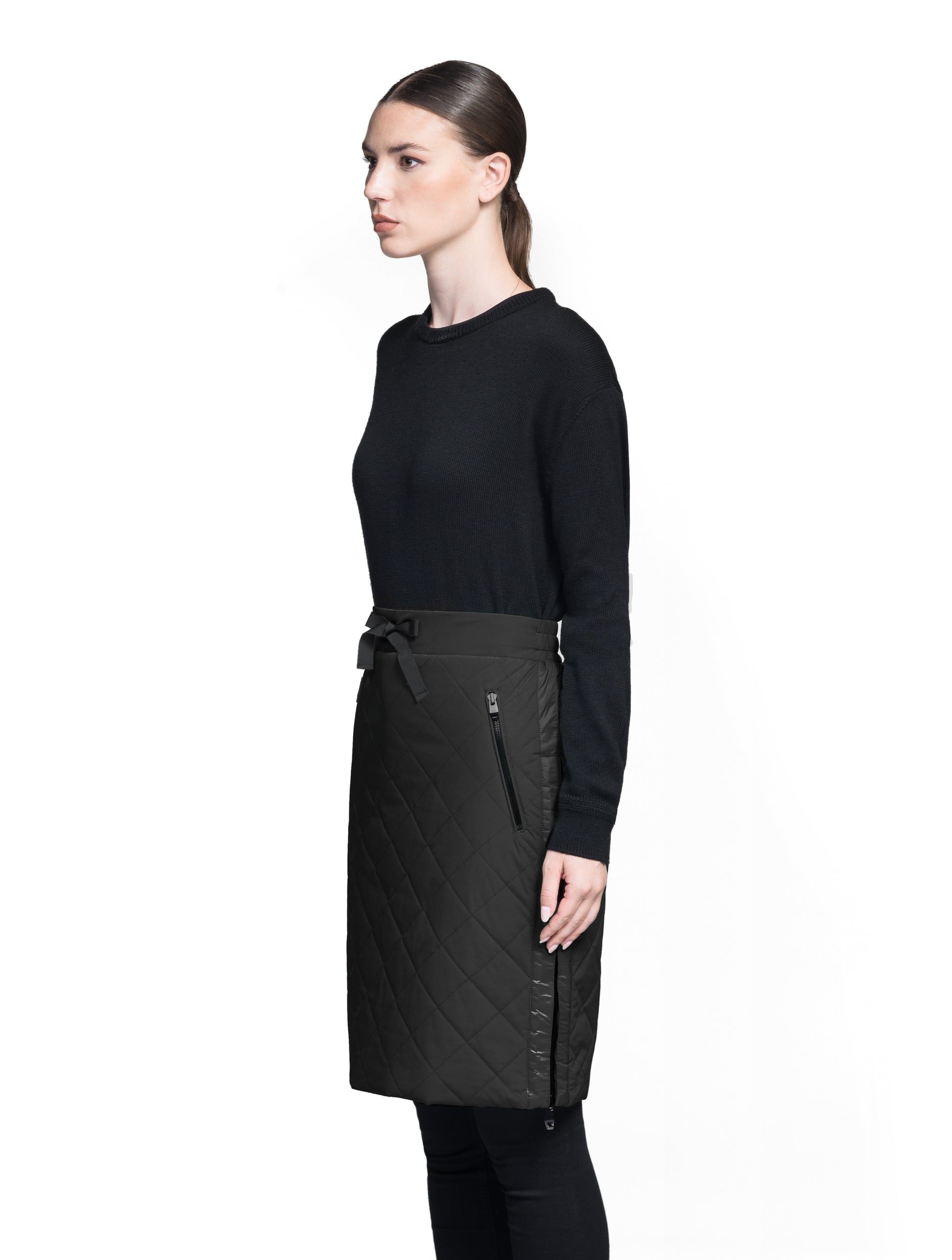 Phora Women's Tailored Skirt in knee length, premium stretch ripstop and contrast cire technical nylon taffeta fabrication, premium 4-way stretch, water resistant Primaloft Gold Insulation Active+, elasticated waistband with grosgrain ribbon drawstrings, two zipper pockets at waist, and zipper closure gusset at side seams, in Black