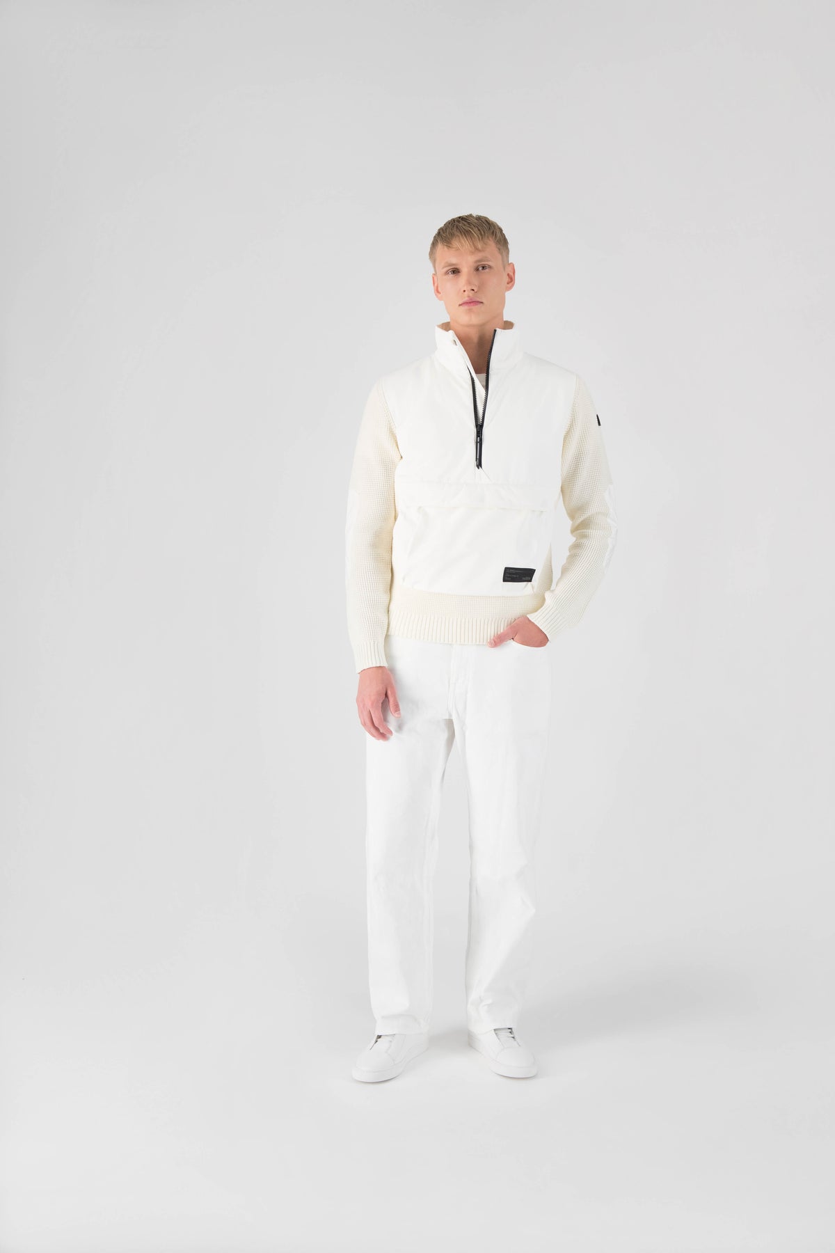 Wai Men's Performance Half Zip Sweater in hip length, 3-Ply Micro Denier and Merino wool knit fabrication, Primaloft Gold Insulation Active+, centre front zipper, flap kangaroo pocket with magnetic closure, and hidden side-entry zipper pockets at waist, in Chalk