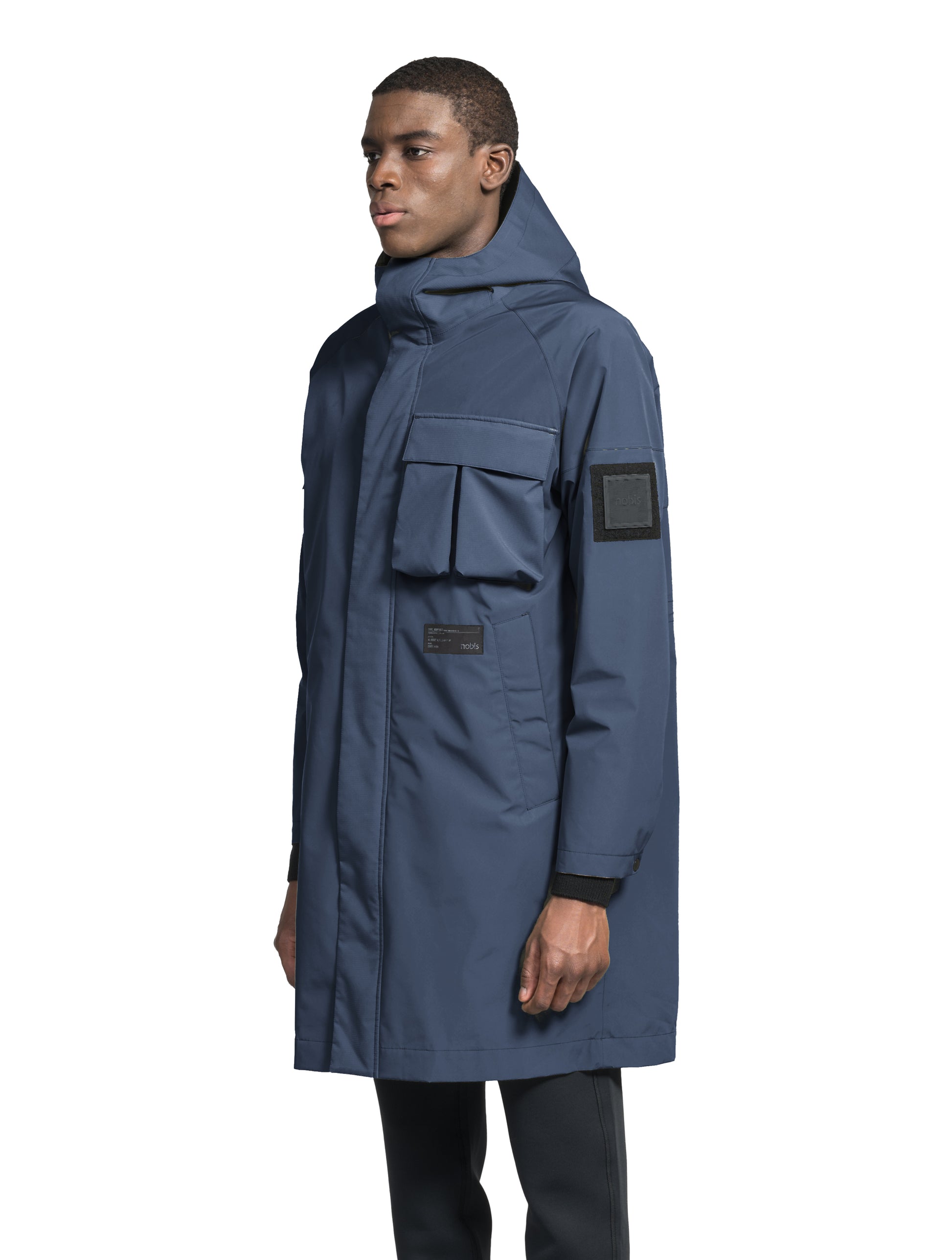 Wylder Men's Performance Rain Jacket in knee length, premium 3-ply Micro Denier and stretch ripstop fabrication, non-removable hood with reflective piping and adjustable draw cord, split utility chest pocket with magnetic flap closure, single welt pockets with magnetic closure at waist, back yoke with mesh ventilation, snap button wind flap, two-way branded zipper at centre front, telescopic sleeves with elasticized cuffs, interior draw cord at waist, in Marine