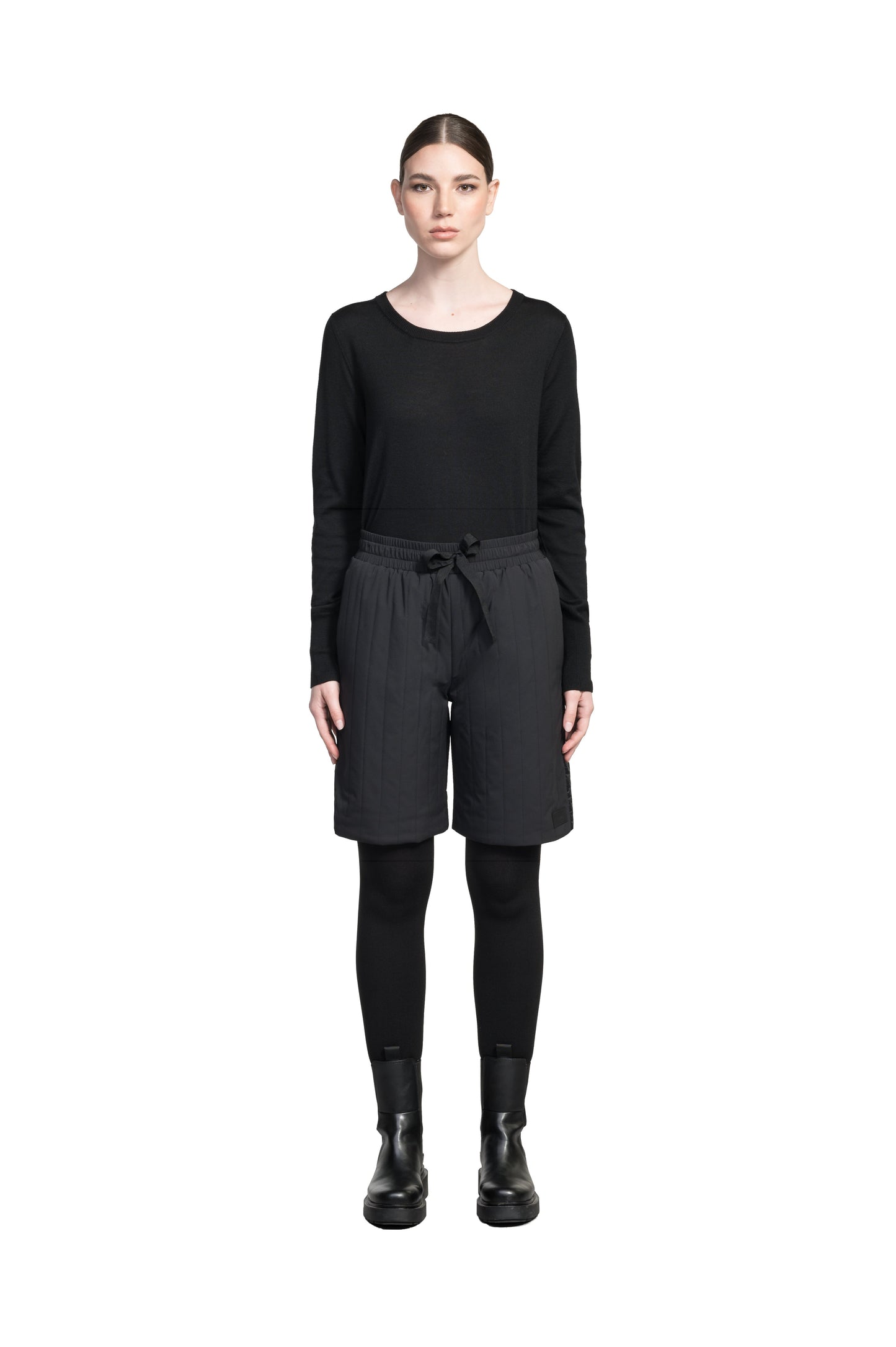 Kit Women's Quilted Shorts in knee length, premium stretch ripstop and contrast cire technical nylon taffeta fabrication, premium 4-way stretch, water resistant Primaloft Gold Insulation Active+, elasticized waistband with grosgrain ribbon drawstrings, hidden side seam toggles for rouching detail, snap closure side seam pockets at hips, and single welt snap button pockets at back, in Black