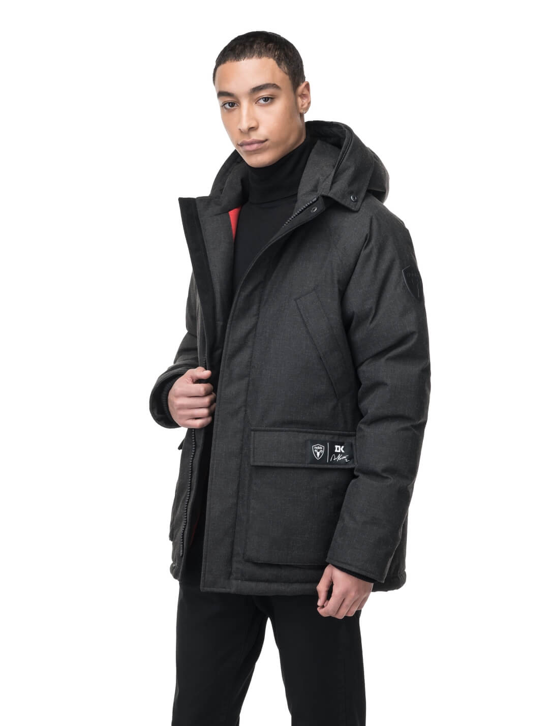 Duncan Keith Heritage Men's Parka in hip length, and features Canadian duck down insulation, non-removable hood with removable coyote fur trim, fleece-lined chest pockets, top and side entry waist pockets, adjustable waist cord, interior zipper pocket, and co-branding with Keith's signature on the left outer waist pocket, in H. Black
