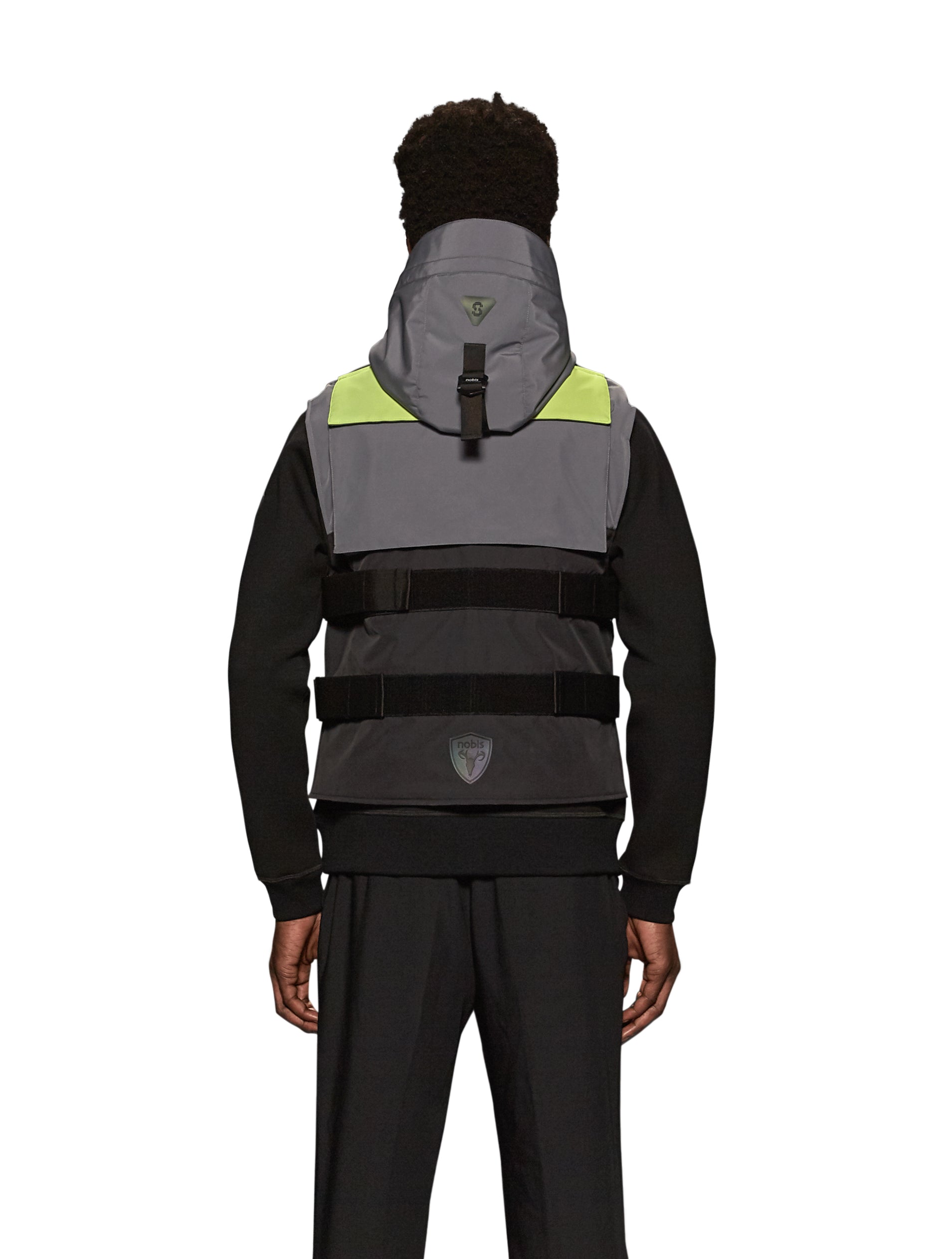 Unisex waist length hooded tactical vest with multiple exterior pockets on front and back, and adjustable side webbing fasteners, colour blocked in Concrete/Black
